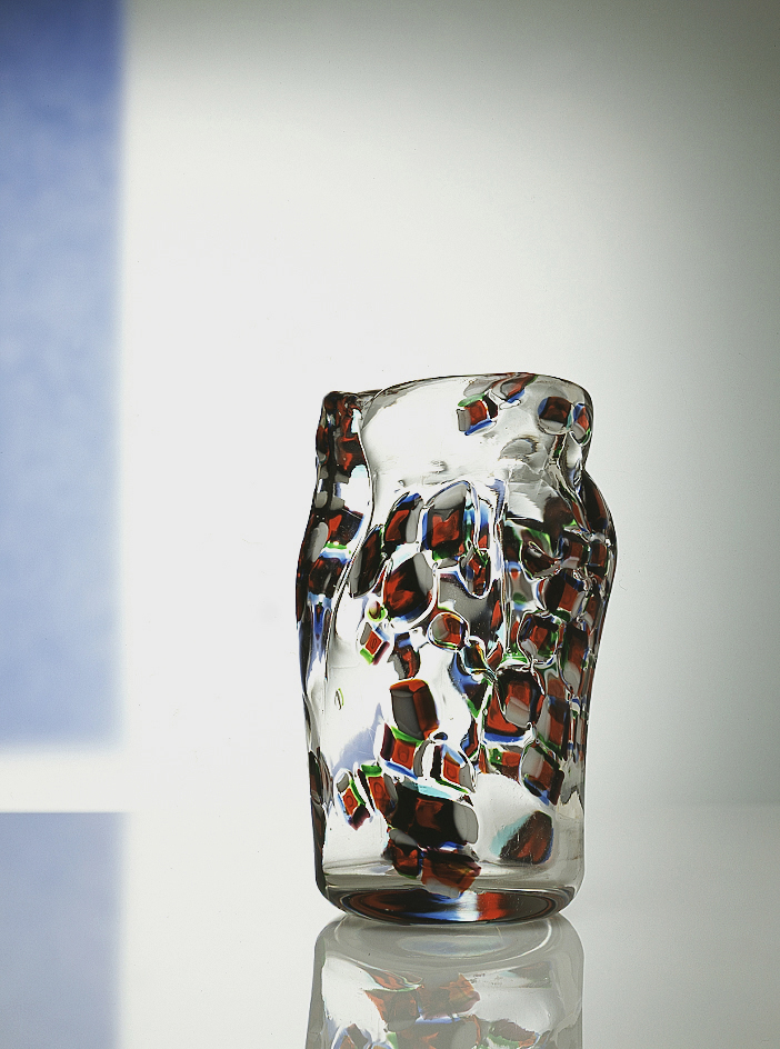 Vaso, 1960 Vaso a forma di corpo di donna in vetro incolore con murrine irregolari di colore rosso, blu, verde e lattimo; cm 13,5 (diam.) x 22,7
